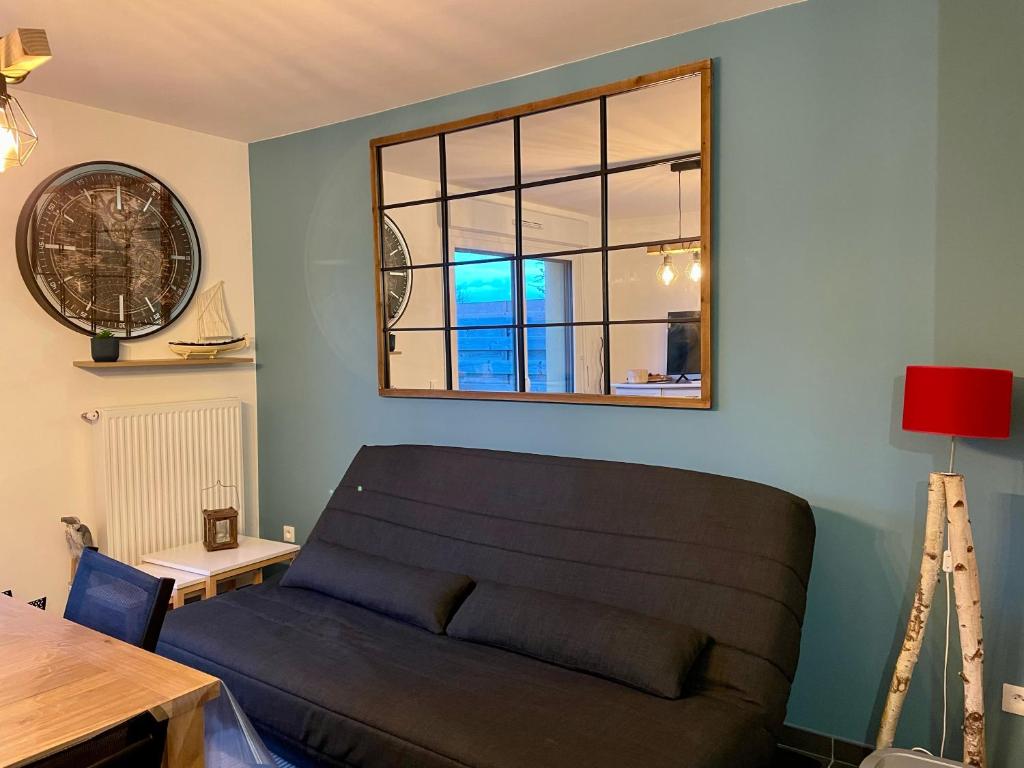 un salon avec un canapé et une fenêtre dans l'établissement Les Lofoten : Maison neuve Résidence Sequoia, à Saint-Valery-sur-Somme