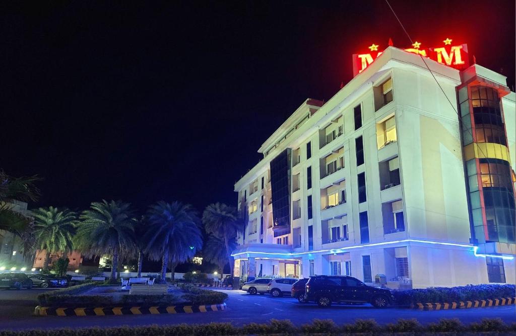 a hotel with a neon sign on top of it at Hotel MGM Grand in Srikalahasti