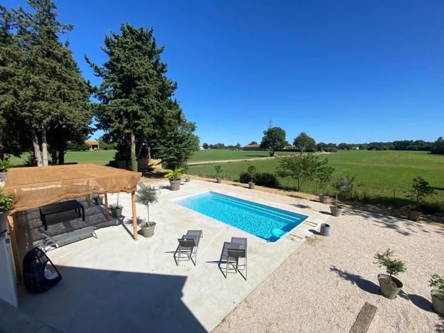 - une piscine dans un jardin avec des chaises et une table dans l'établissement La Villa de Marius, à Arles
