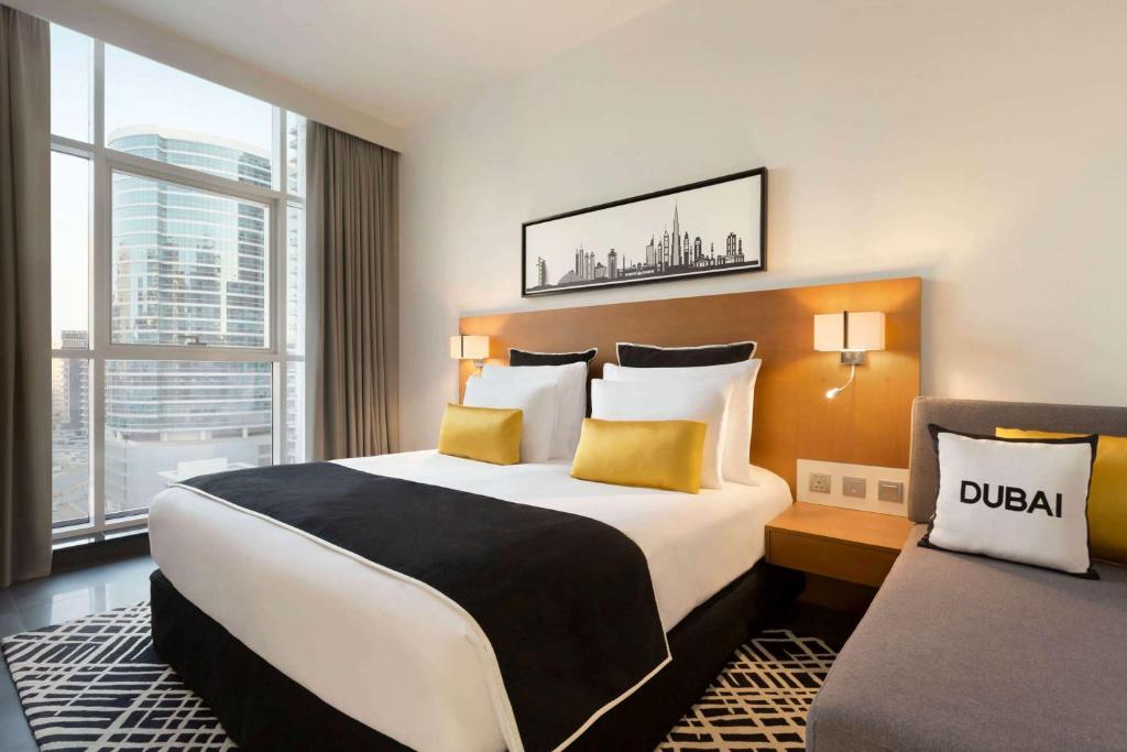 a hotel room with a large bed and a window at TRYP by Wyndham Dubai in Dubai