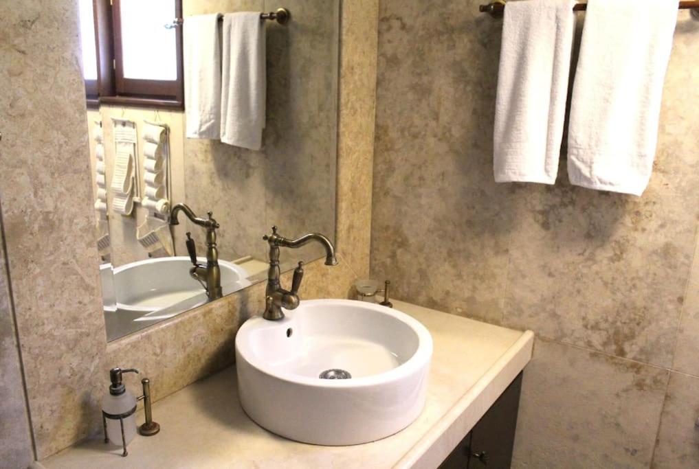 a bathroom with a white sink and a tub at Elis studio luxury apartment in Ierápetra