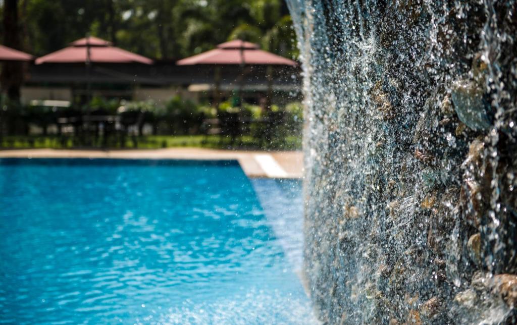 a water fountain in front of a swimming pool at Rose Garden Hotel in Yangon