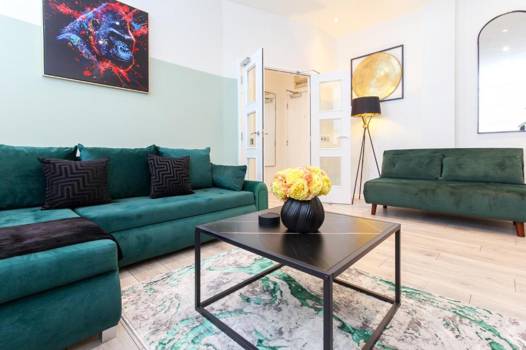 a living room with green couches and a table at The Lanes Royale - Rose Platinum Properties in Brighton & Hove