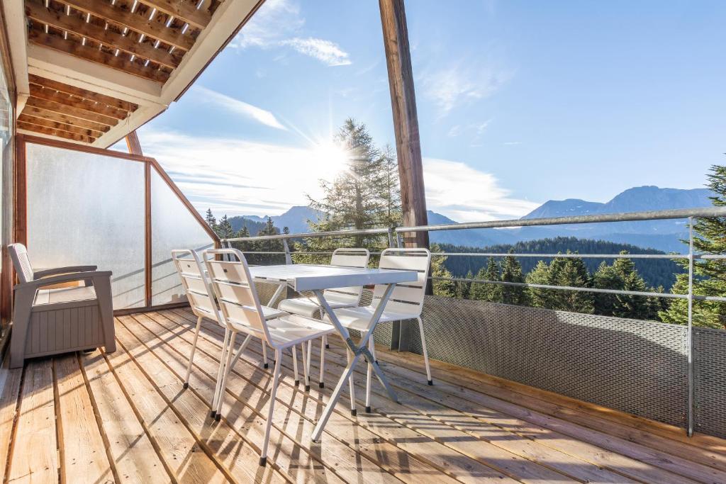 un balcon d'une maison avec une table et des chaises dans l'établissement Hermine - apt 6p vue montagne, à Chamrousse