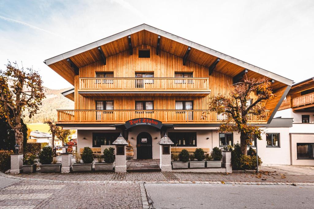 a wooden building with a balcony on top of it at DORFSTUDIO Apartments in Söll