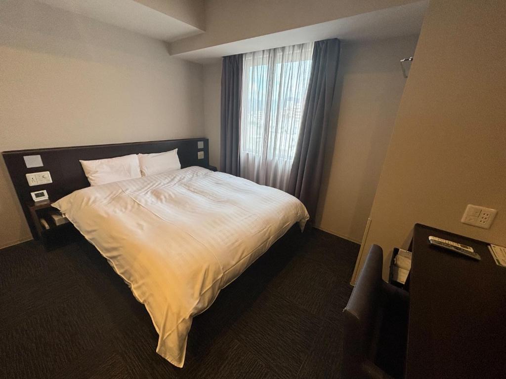 Postel nebo postele na pokoji v ubytování Dormy Inn Kochi