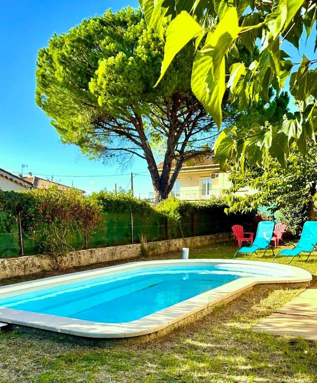 - une piscine dans une cour avec 2 chaises et un arbre dans l'établissement Villa la Farigoule, à Carpentras