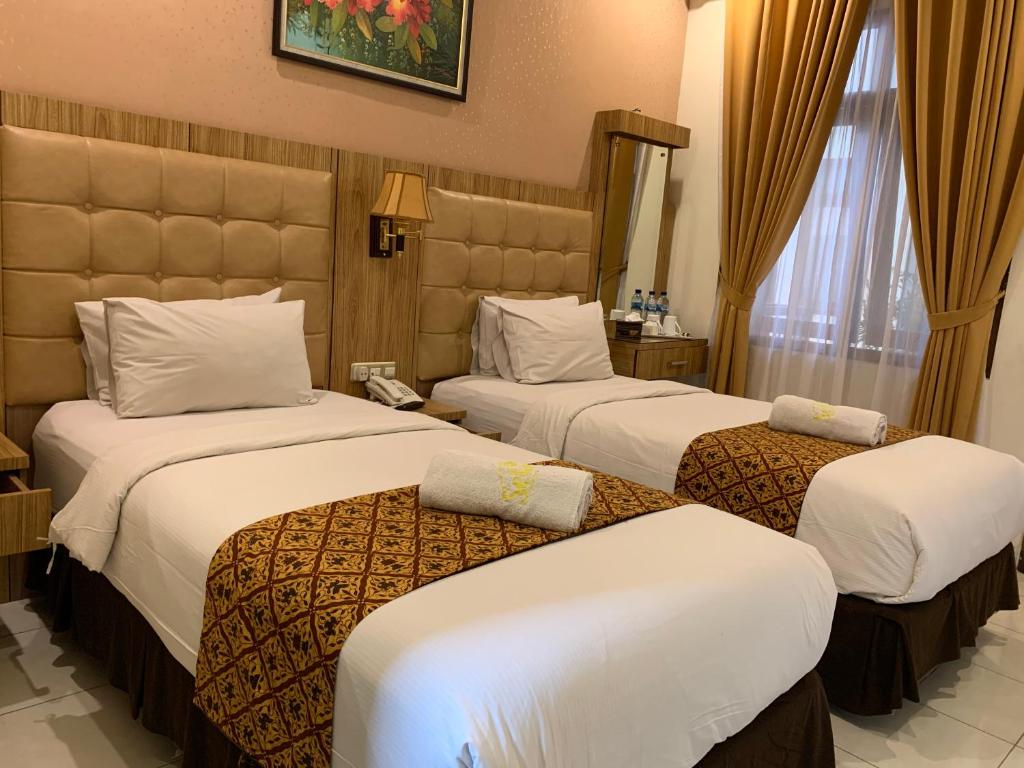 Postel nebo postele na pokoji v ubytování Selaras Inn Syariah