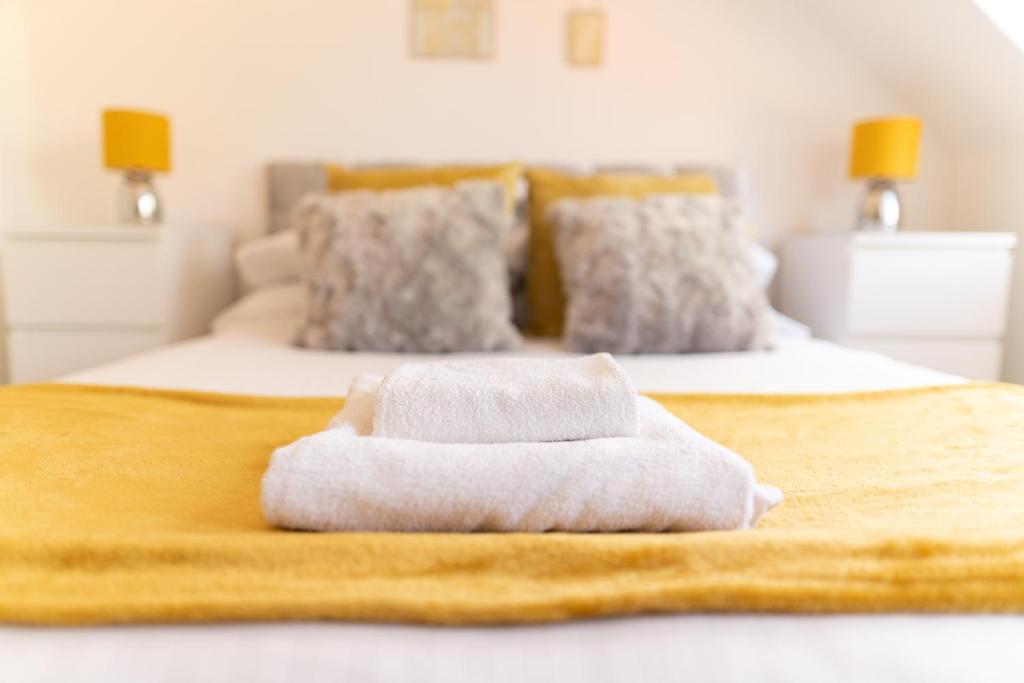 two towels sitting on top of a bed at Beautiful town centre apartment in Huntingdon