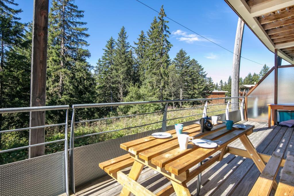 une table en bois sur le pont d'une cabane dans les arbres dans l'établissement Aventures à Chamrousse - Appt 34 m² avec terrasse, à Chamrousse
