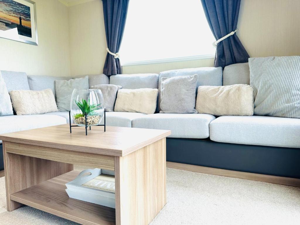 a living room with a couch and a table at Barn Owl Lodge in Bridlington
