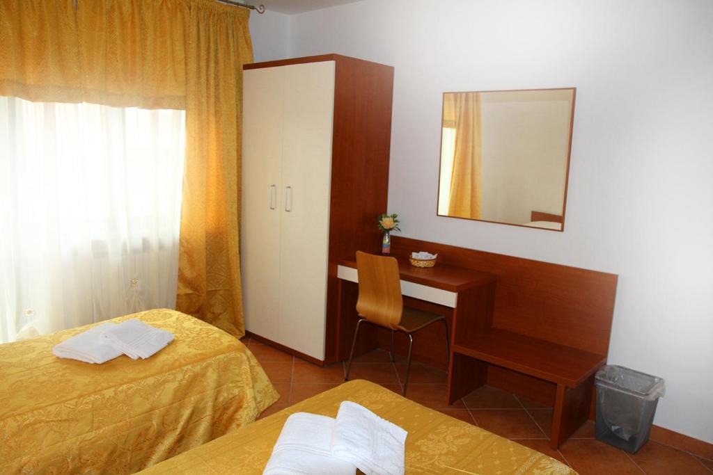 a room with two beds and a desk and a mirror at B&B Music in Milan
