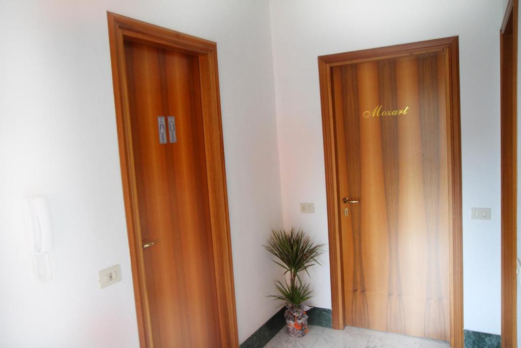 two wooden doors in a room with a plant at B&B Music in Milan