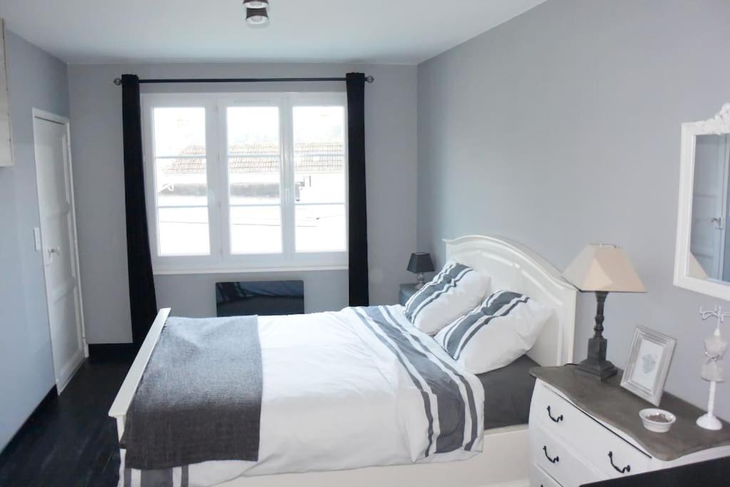 a bedroom with a white bed and a window at Le Baluchon Portais - Gîte de Charme in Port-en-Bessin-Huppain