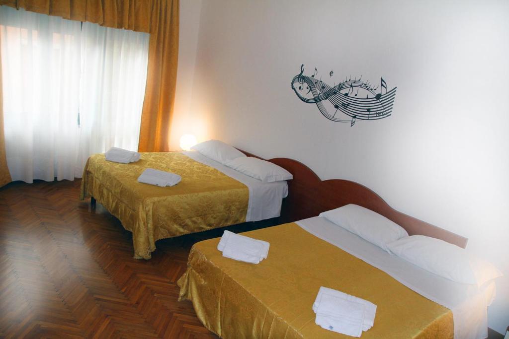a hotel room with two beds and a fish sign on the wall at B&B Music in Milan