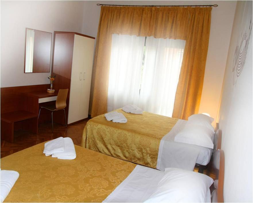a hotel room with two beds and a desk at B&B Music in Milan