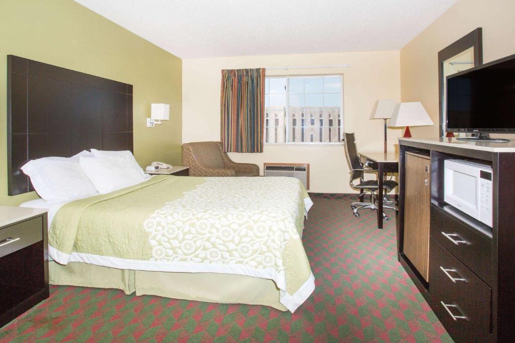 a hotel room with a bed and a flat screen tv at Days Inn by Wyndham Lexington NE in Lexington