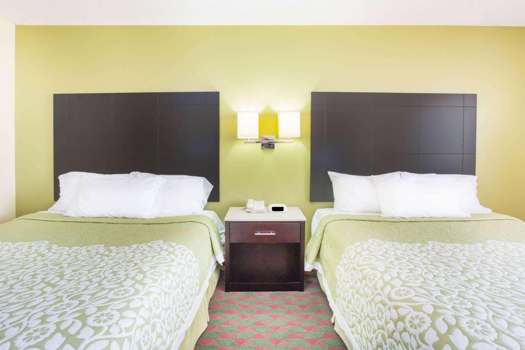 a hotel room with two beds with white sheets at Days Inn by Wyndham Lexington NE in Lexington
