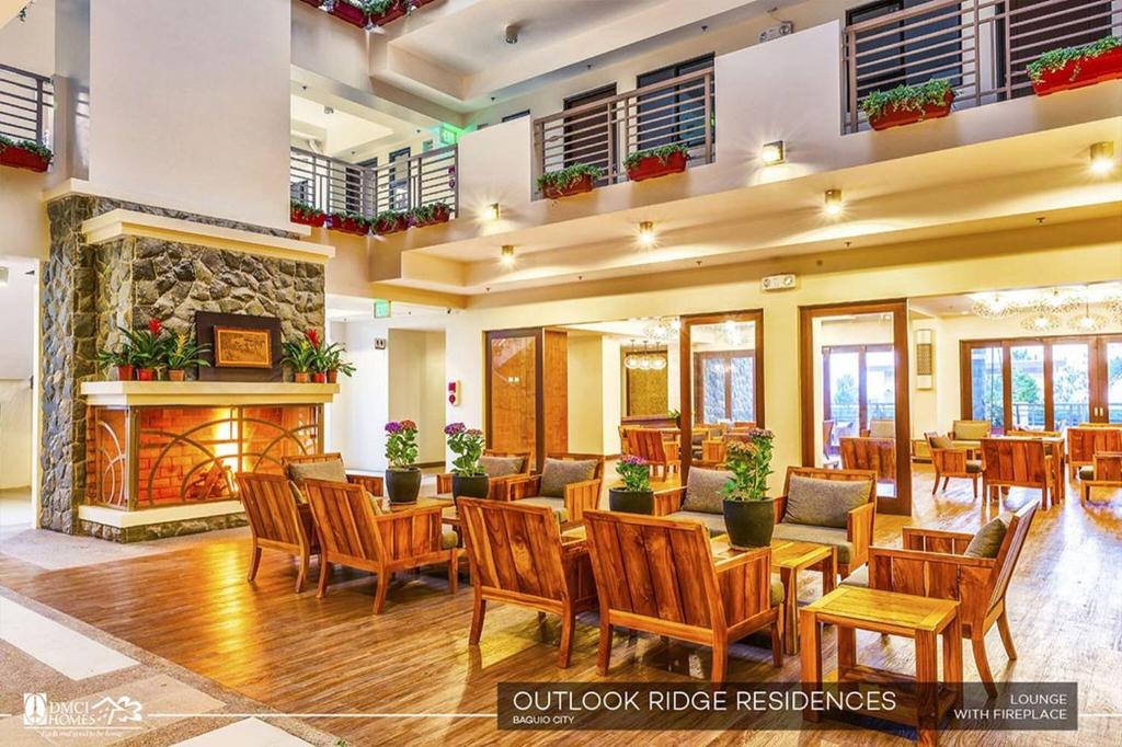 Un restaurante con mesas y sillas y chimenea. en Condo Unit Outlook Residences Baguio, en Baguio