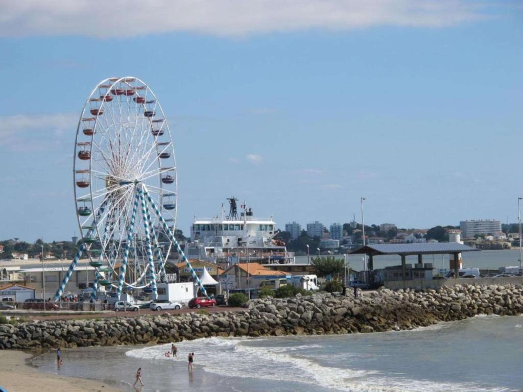 a ferris wheel on the beach next to the ocean at Best Western Hôtel Royan Océan in Royan