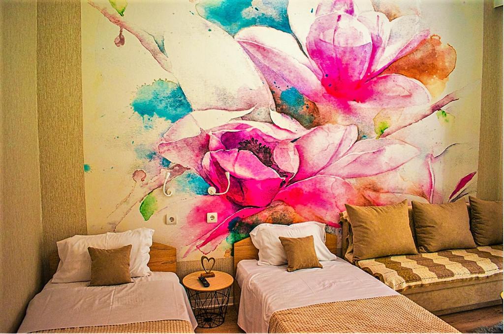 a room with two beds and a painting of a flower at Ayasofia Suite jakuzzi 2 BedRooms balcony in Thessaloniki