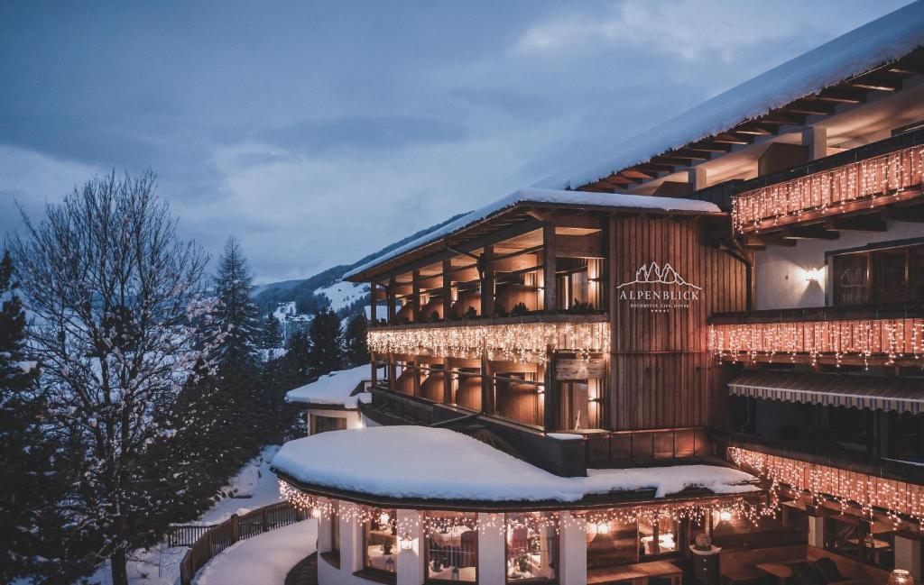 セストにあるHotel Alpenblickの雪面のクリスマスライトで覆われた建物