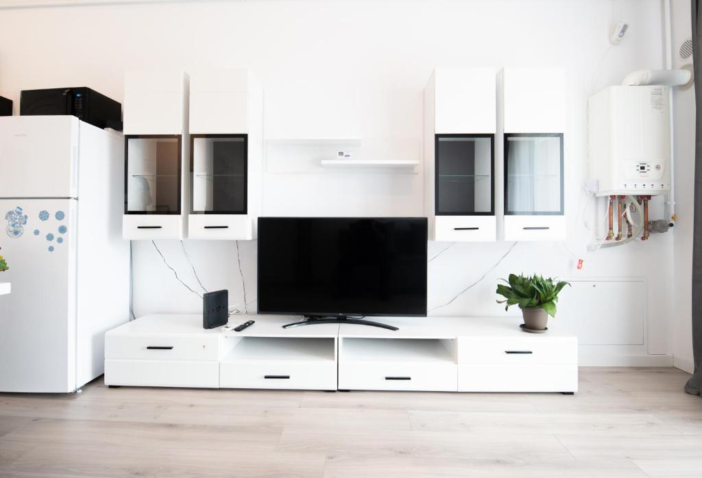 a white living room with a tv on a white cabinet at Modern Chic Apartment - near Iulius Mall in Timişoara