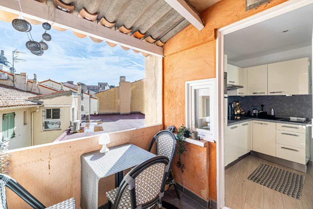 un balcon avec une table et des chaises et une cuisine dans l'établissement LE CONTEMPORAIN adorable avec petite terrasse, emplacement idéal dans le centre, à Cannes