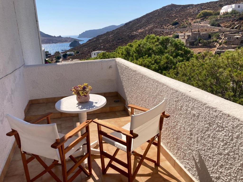 a table and two chairs on a balcony with a view at Golden Sun Hotel Patmos in Patmos