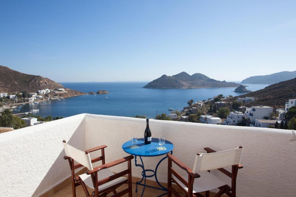 Una mesa y sillas en un balcón con vista al mar. en Golden Sun Hotel Patmos, en Patmos