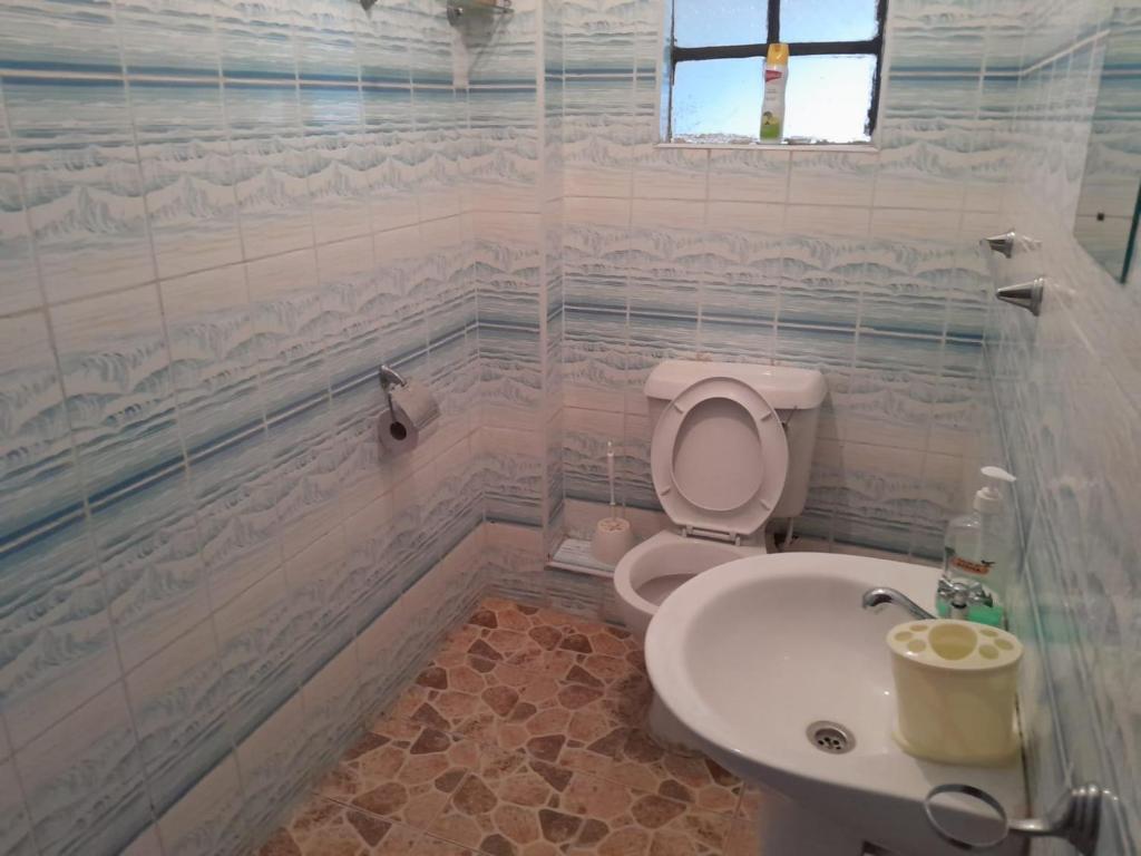 a bathroom with a toilet and a sink at Evergreen Kile homes in Nairobi