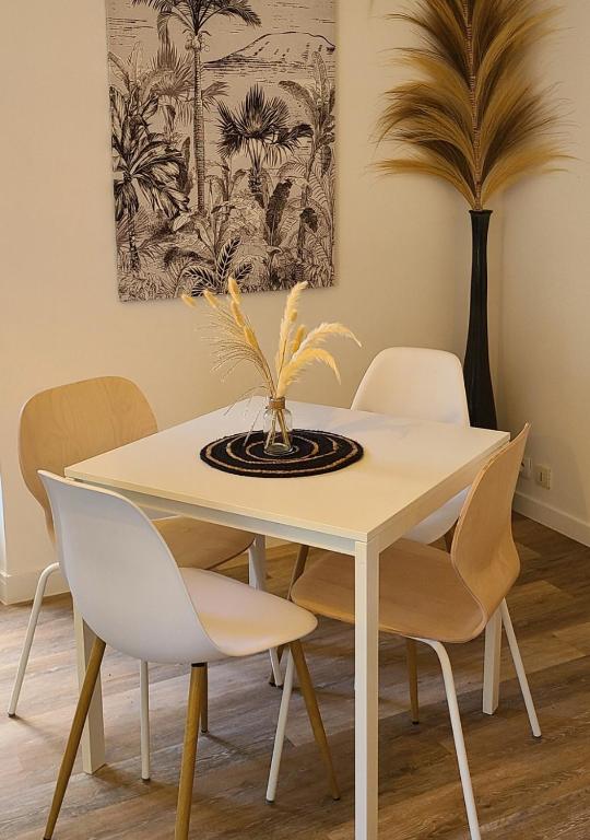 une salle à manger avec une table et des chaises blanches dans l'établissement L'Evasion Chill, à Saint-Brieuc