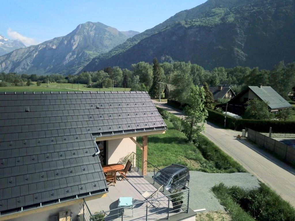 une maison avec un toit et des montagnes en arrière-plan dans l'établissement Lodge Fabisa, à Le Bourg d'oisans