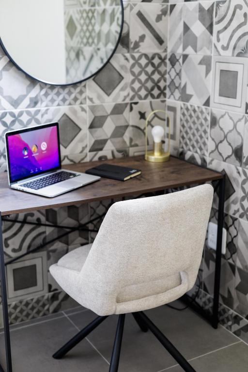 a desk with a laptop and a white chair at 4 Lulworth in Johannesburg