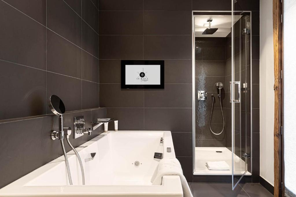 a bathroom with a bath tub and a shower at Le Kaïla in Méribel