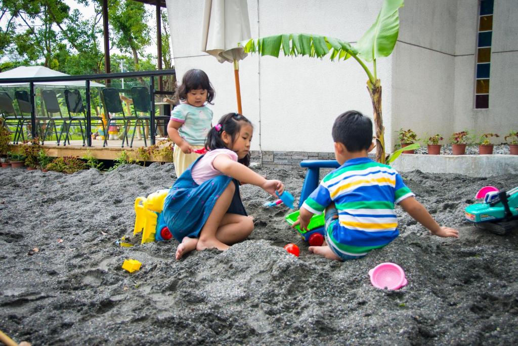 three children playing in the sand in a sandbox at Hai Yue Wan Resort Club in Shunan