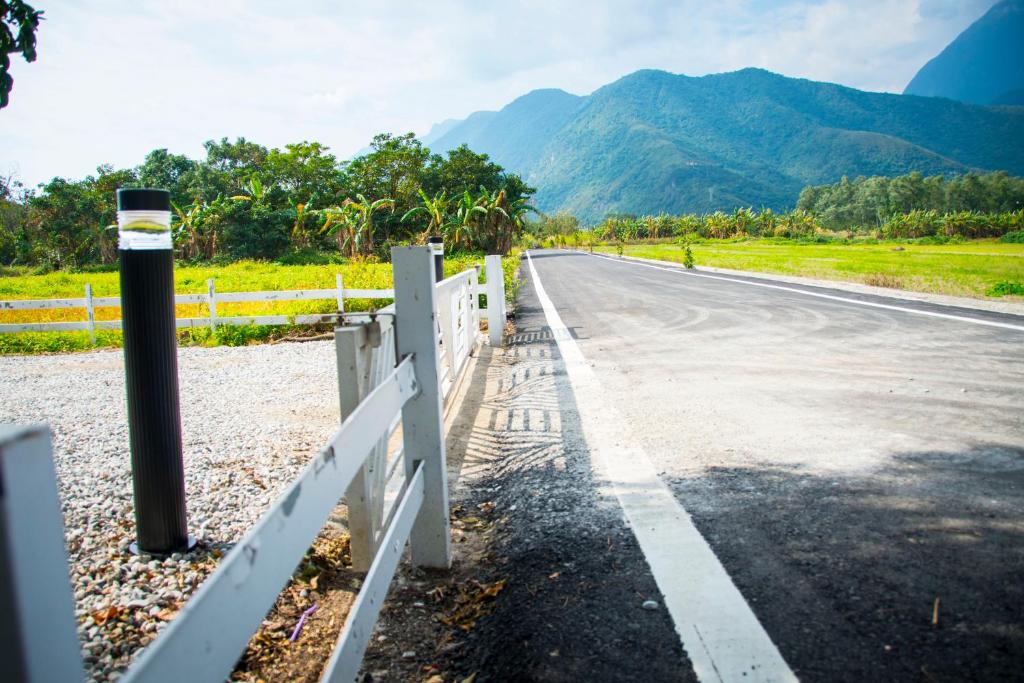 an empty road with a fence and mountains in the background at Hai Yue Wan Resort Club in Shunan