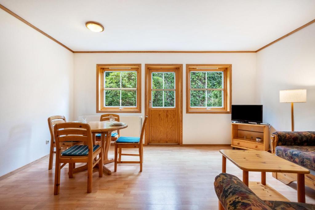 a living room with a table and chairs and a couch at Haus Albatros Wohnung 3 in Ostseebad Koserow
