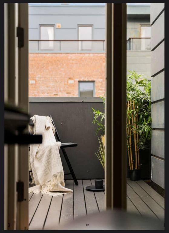 an open door to a balcony with a chair at Large Room with Balcony -two storey condo- nearby Scandic Business Center bus stop in Stavanger