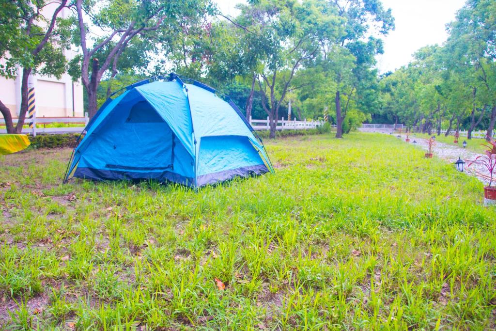a blue tent sitting in the grass in a field at Hai Yue Wan Resort Club in Shunan