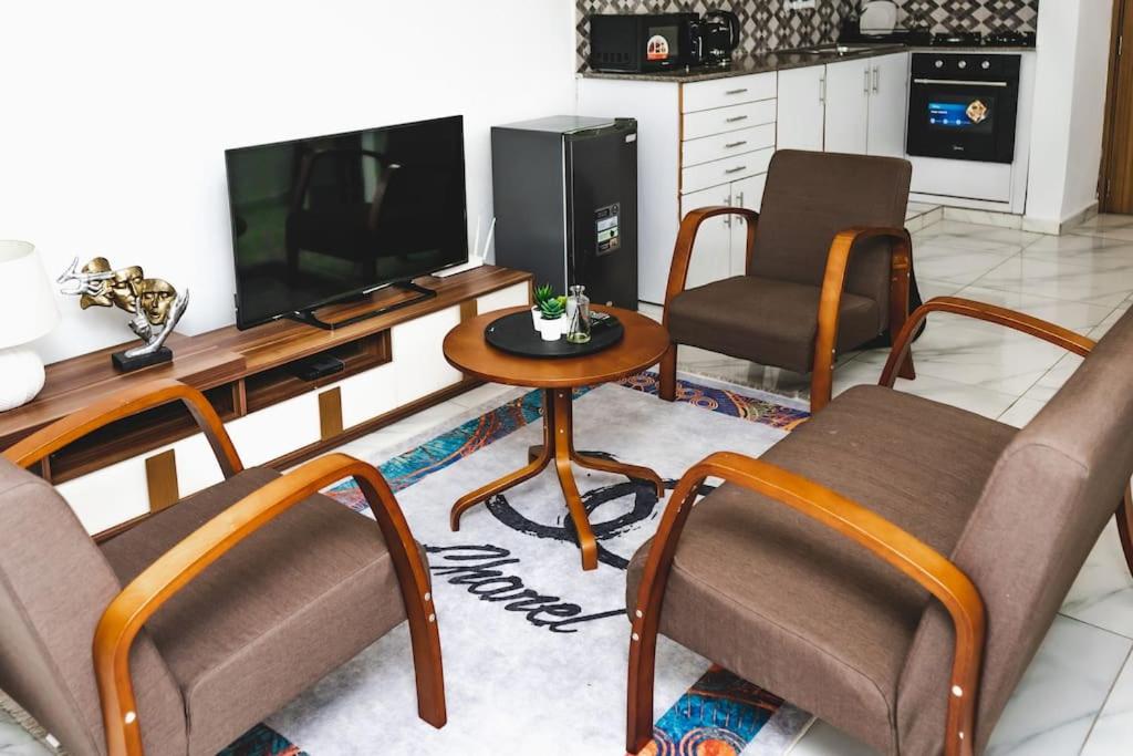 een woonkamer met 3 stoelen en een televisie bij Appartement 2pièces et terrasse in Abidjan