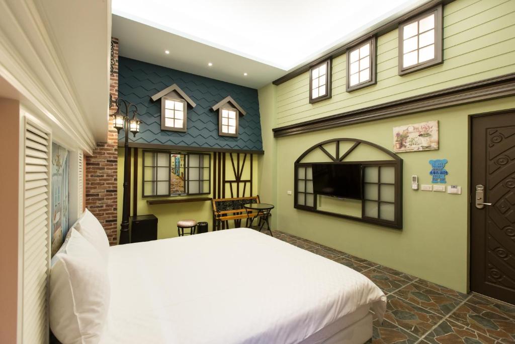 a bedroom with a bed and a house at Bookline B&amp;B in Hualien City