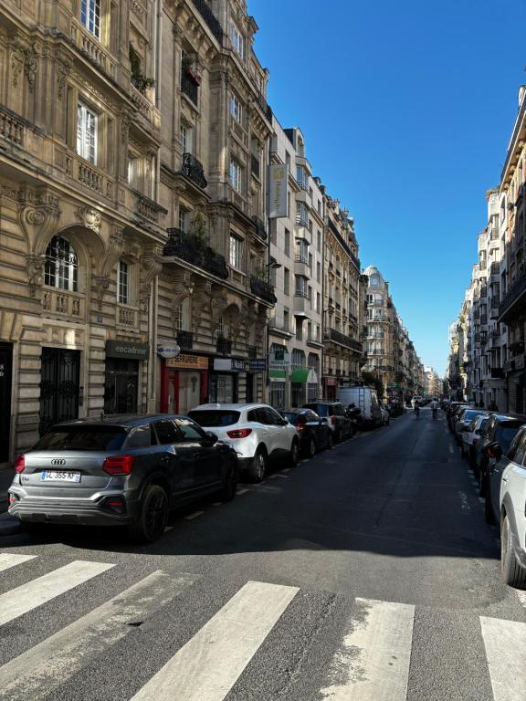 une rue avec des voitures garées sur le côté d'un bâtiment dans l'établissement Pretty Montmartre, à Paris