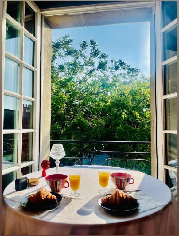 une table avec deux assiettes de nourriture et une fenêtre dans l'établissement One Room Apartment in Paris Montmartre, à Paris