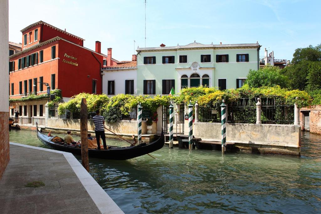 a gondola is docked in a canal next to buildings at Pensione Accademia - Villa Maravege in Venice