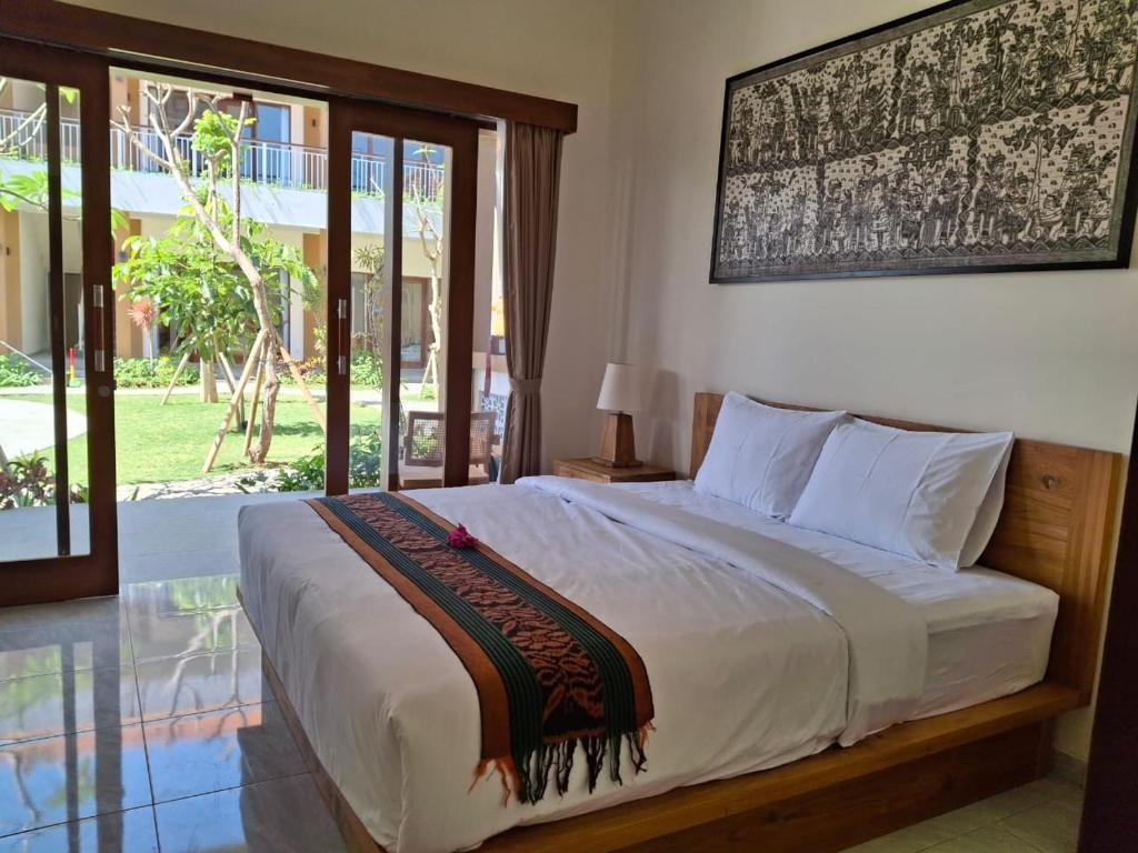 Un dormitorio con una cama y una ventana grande. en Omah Santai Canggu, en Canggu