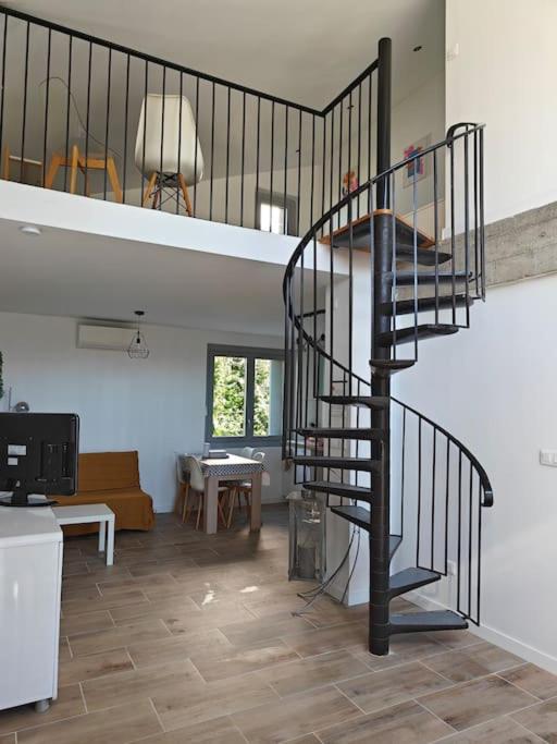 - un salon avec un escalier en colimaçon dans une maison dans l'établissement Duplex 4 personnes, à Saint-Gaudens