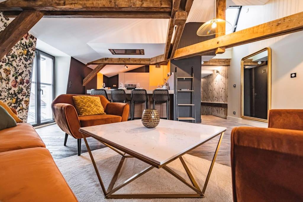 - un salon doté d'un mobilier orange et d'une table dans l'établissement Au Coin de Saint-Jacques Reims hypercentre, à Reims