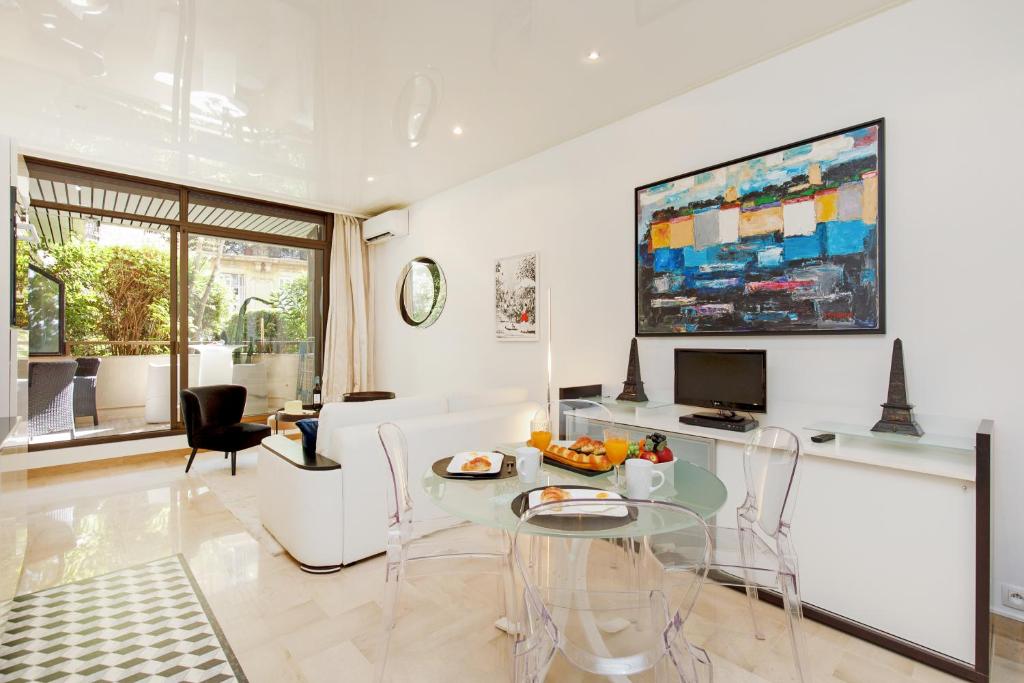 un salon avec une table en verre et des chaises dans l'établissement Gray d'Albion 1D1 YourHostHelper, à Cannes