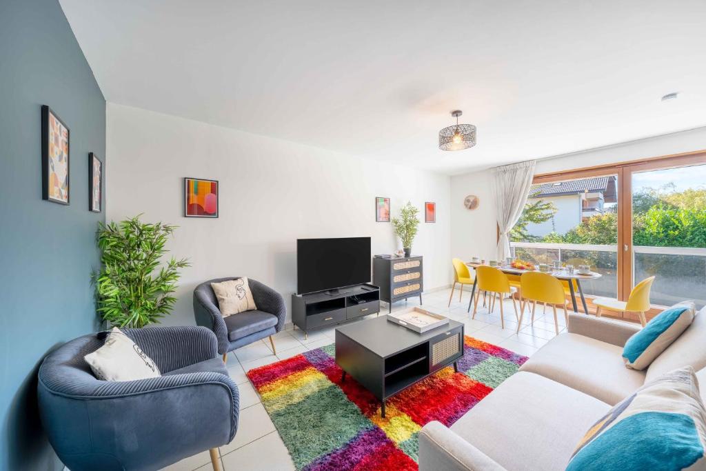 un salon avec un canapé, des chaises et une télévision dans l'établissement Lartdeco, à Thonon-les-Bains